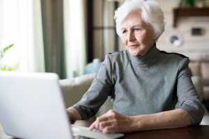 Femme âgée devant ordinateur dossier réversion agirc-arrco