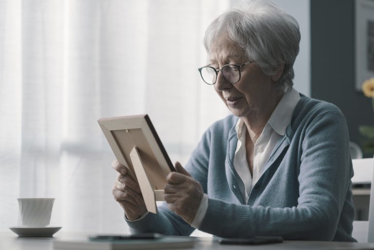 Veuve triste regarde photo de son mari décédé