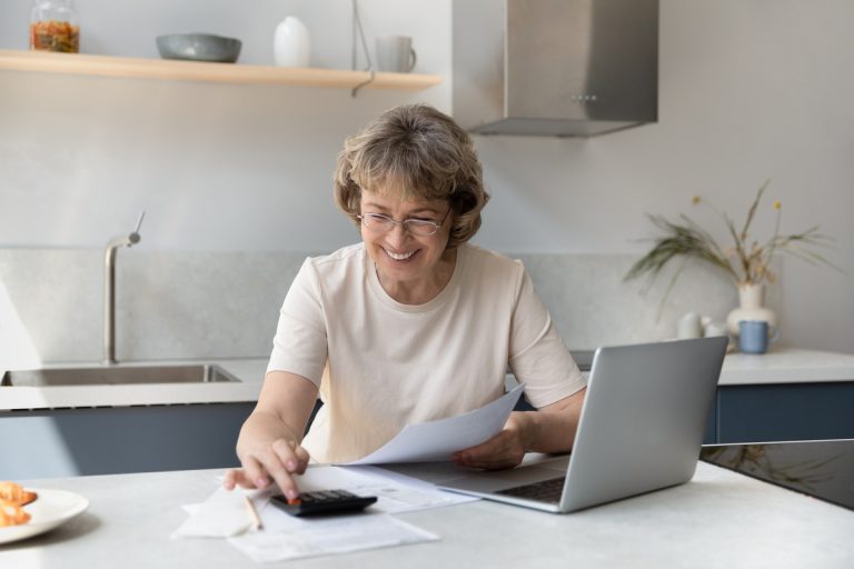 Femme retraitée calculant prime carburant calculette