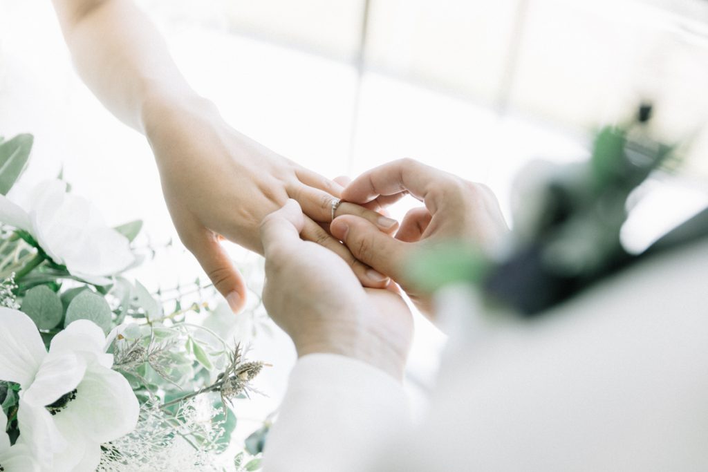 Homme passant la bague au doigt de son épouse mariage