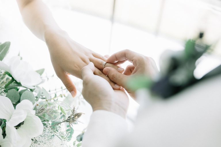 Homme passant la bague au doigt de son épouse mariage