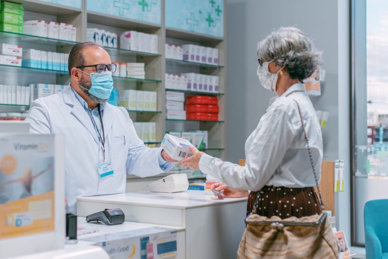 femme âgée récupérant masques gratuits à la pharmacie