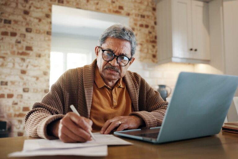 Senior rédigeant sa demande de départ à la retraite à la maison