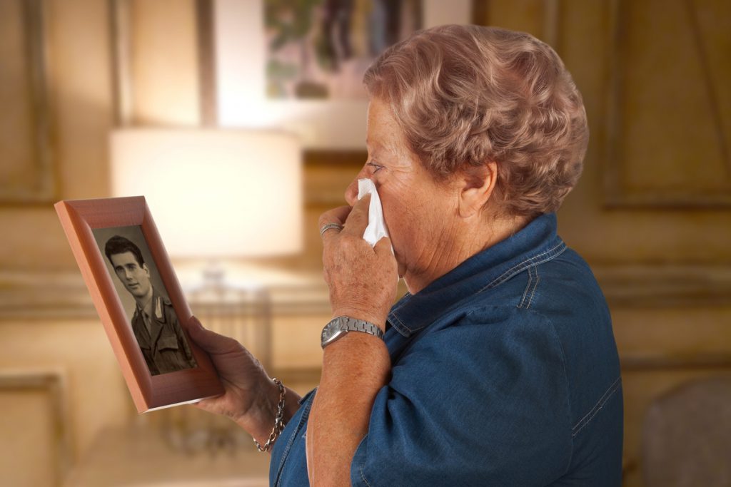 veuve de guerre triste devant photo mari soldat