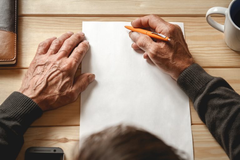homme âgée écrivant une lettre