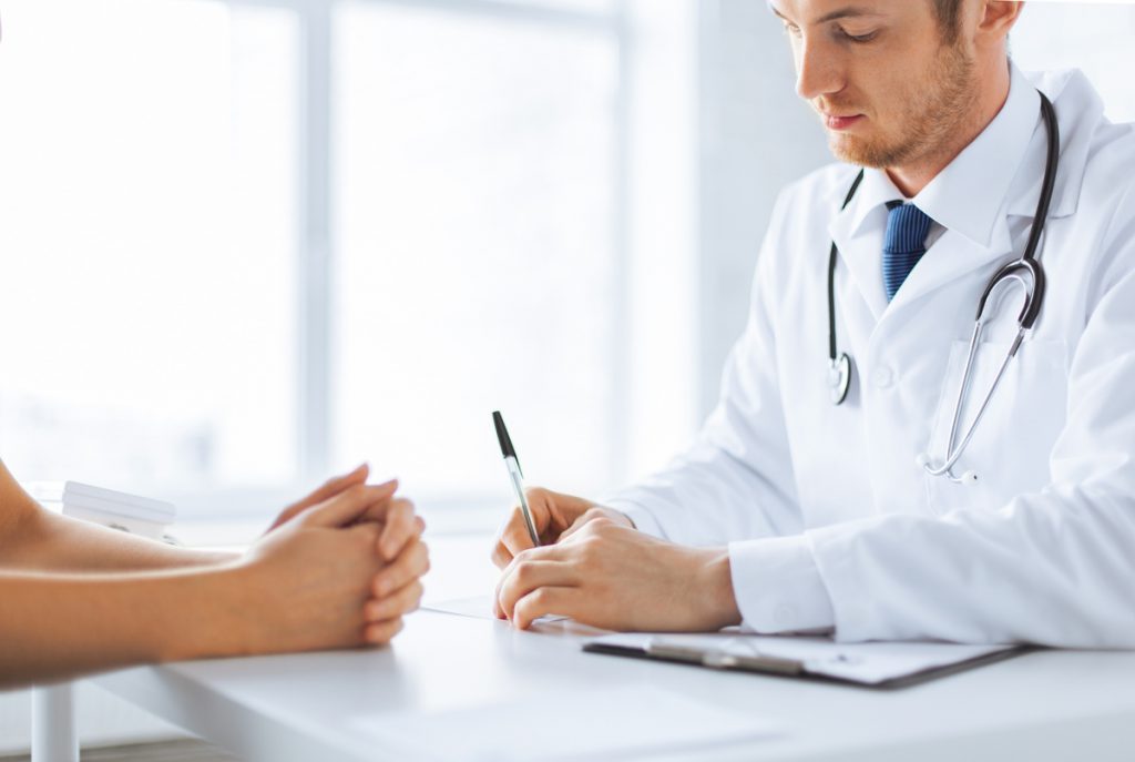patient and doctor taking notes | Pension de reversion docteur avec patiente