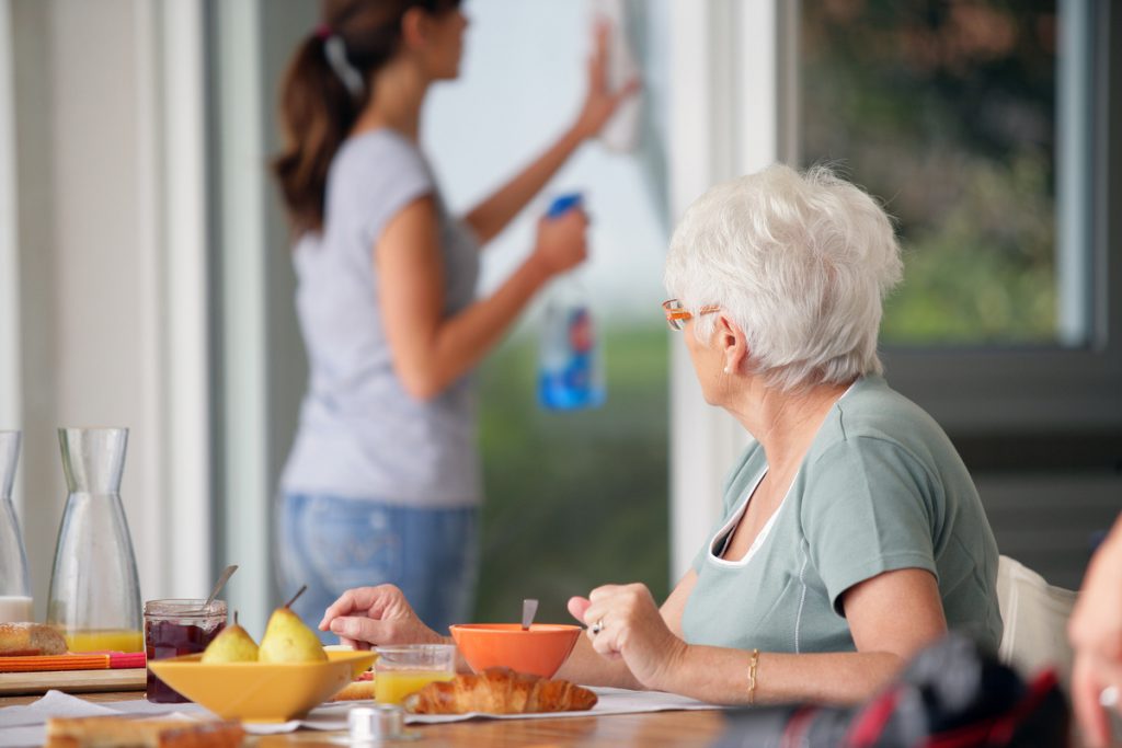 Femme agée prenant son petit déjeuner observant une femme | Pension de reversion CESU employée à domicile