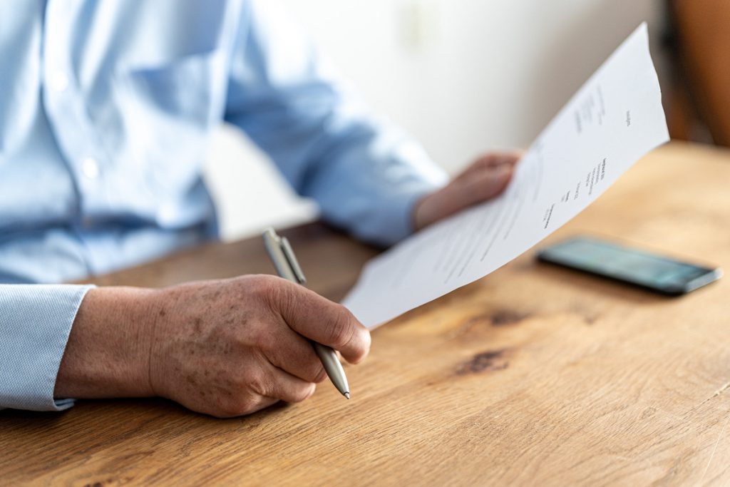 Homme rédigeant une lettre | Pension de reversion pension de réversion et RSA