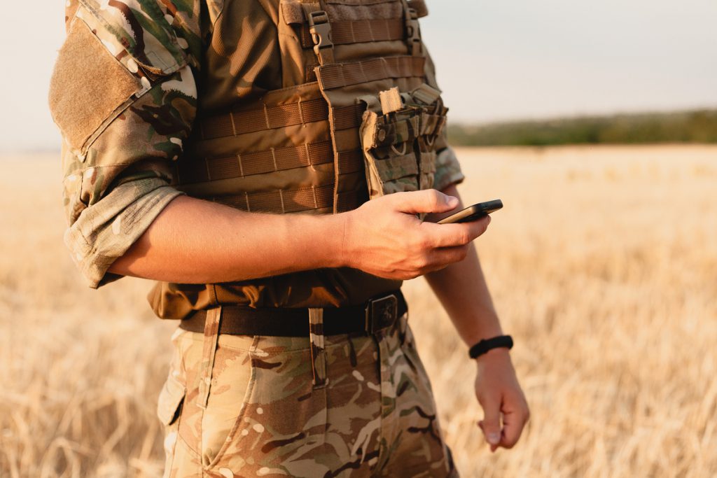 Mid section of military soldier using mobile phone | Pension de reversion