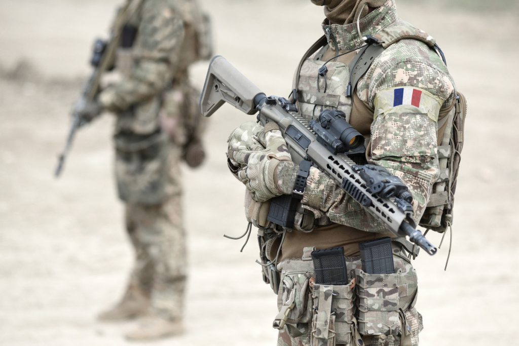 Soldiers with assault rifle and flag of France on military unifo | Pension de reversion Service militaire et retraite