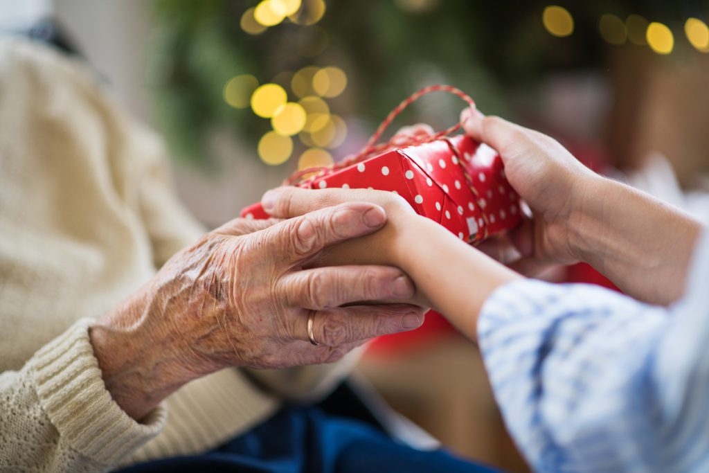 Close-up of hands of senior and young woman holding a present at Christmas. | Pension de reversion