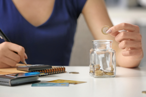 Woman counting coins at table. Savings concept | Pension de reversion