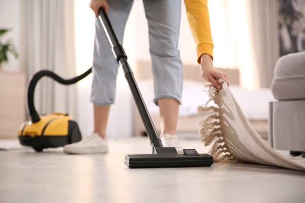 Young woman using vacuum cleaner at home, closeup | Pension de reversion
