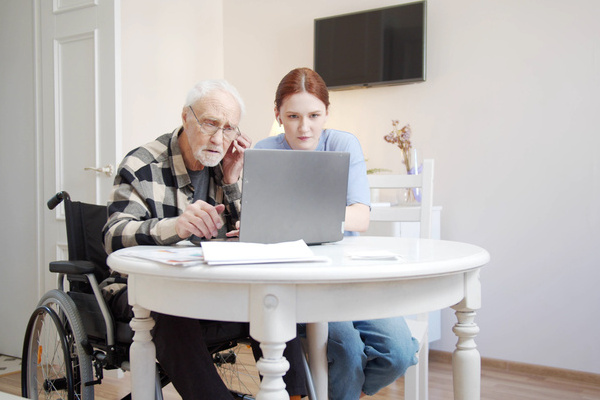 The girl explains to her grandfather how to use headphones and turns on music from his laptop | Pension de reversion