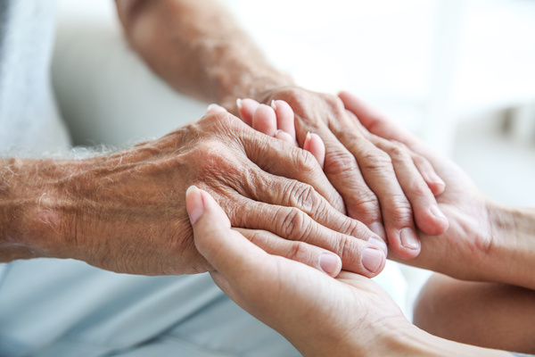 Young woman holding senior man hands, closeup | Pension de reversion aide exceptionnelle