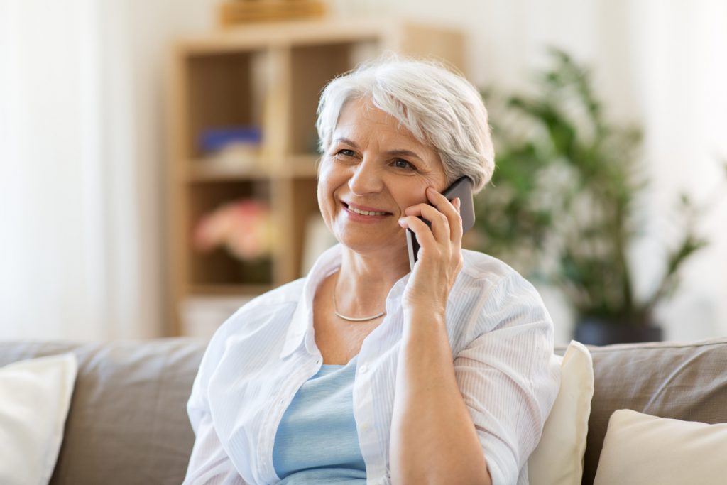 senior woman calling on smartphone at home | Pension de reversion Formulaire de contact
