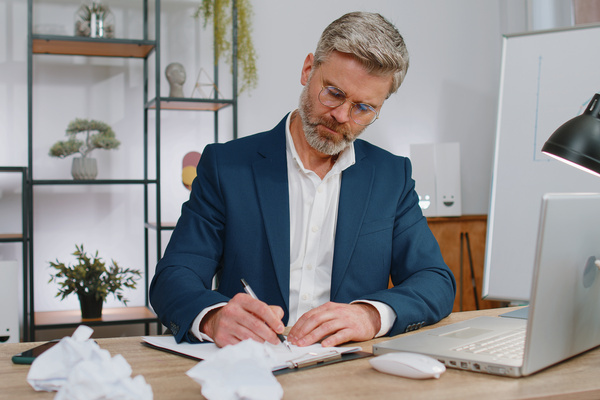 Angry furious man working at home office throwing crumpled paper, having nervous breakdown at work | Pension de reversion corriger erreur de calcul retraite