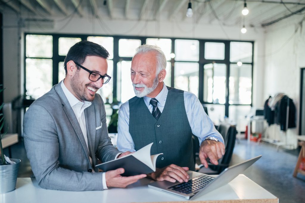 Portrait of young and senior business men working together. | Pension de reversion retraite trop de trimestres