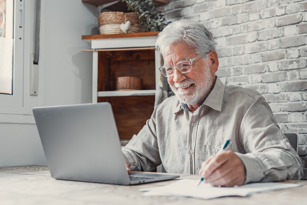 Aged remote worker. Concentrated senior male in glasses work on | Pension de reversion suspension pension de réversion