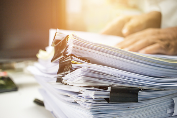Businessman hands searching data information in Stack of papers | Pension de reversion retrouver un bordereau d'indemnités journalières maladie