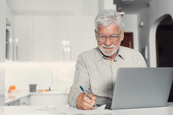 Aged remote worker. Concentrated senior male in glasses work on | Pension de reversion réforme des retraites