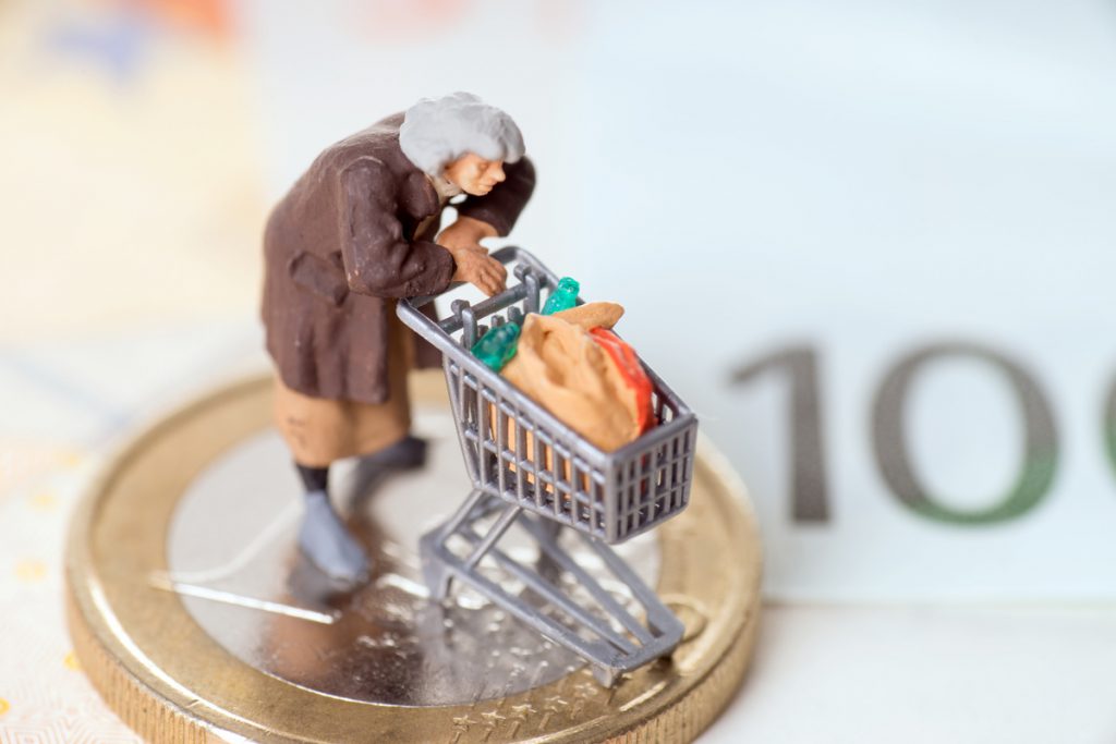 Alte Frau mit Einkaufswagen auf einem Geldstück mit Banknoten | Pension de reversion changements Aspa