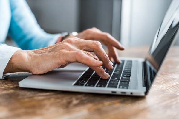 partial view of senior woman typing on laptop at home | Pension de reversion