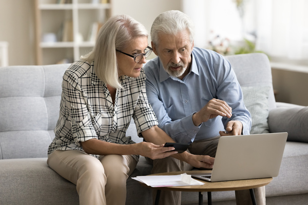 Serious senior married couple calculating domestic expenses | Pension de reversion nouveau dispositif solidarité
