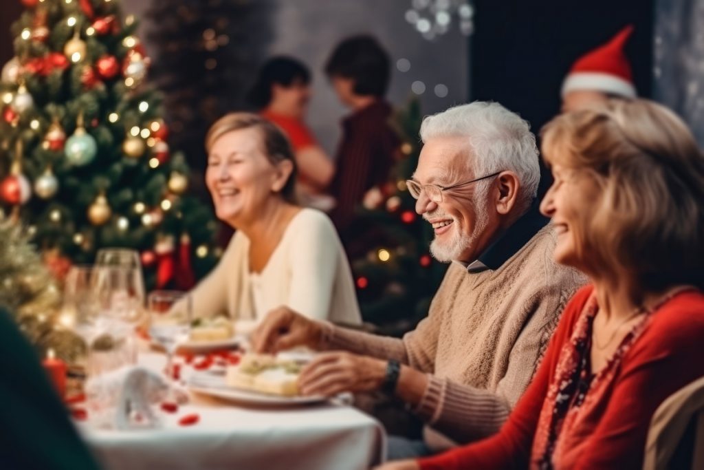 An elderly couple, a man and a woman, sit at the Christmas table. Christmas atmosphere of happiness | Pension de reversion prime de Noël
