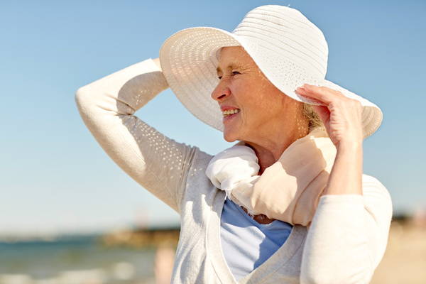 happy senior woman in sun hat on summer beach | Pension de reversion