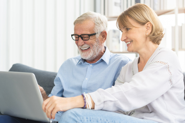 Happy senior couple, elderly family, caucasians mature, adult lover and retired man, woman using laptop computer shopping online, reading news on sofa at home together. Husband and wife lifestyle. | Pension de reversion deuxième rente