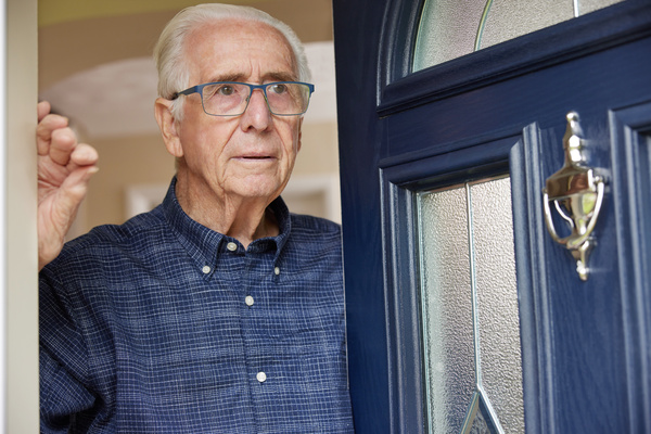 Anxious Senior Man At Home Looking Out Of Front Door | Pension de reversion escroquerie seniors