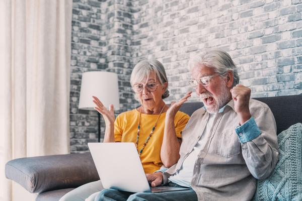 Excited senior mature couple surprised by good unbelievable news, unexpected win, huge shopping sale offer on website, astonished older middle aged family looking at computer screen feeling amazed. | Pension de reversion suppression malus retraite complémentaire