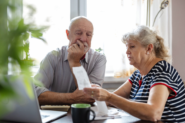 Senior couple discussing their home finances while sitting at the table | Pension de reversion retraite complementaire en retard