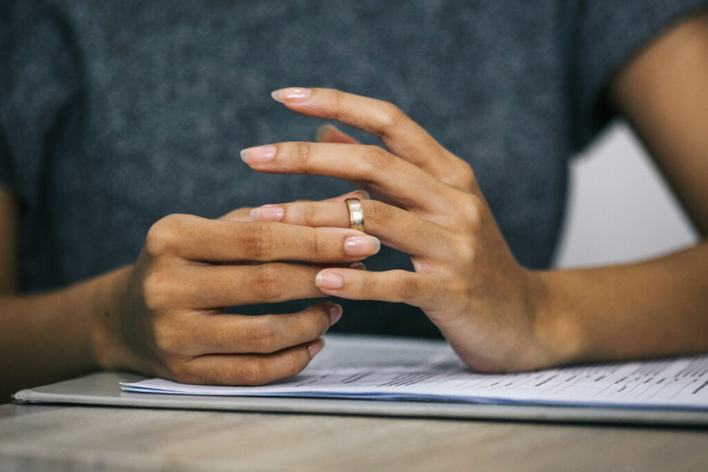 Woman pulling a wedding ring from finger Divorce and ending of relationship concept | Pension de reversion succession et conjoint survivant