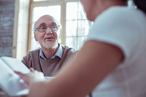 Attentive bearded man listening to his social helper | Pension de reversion entretien rdv retraite