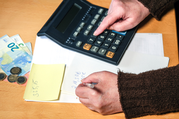 Ãltere arme Frau zählt Geld mit einem alten Taschenrechner zusammen und macht sich Notizen †selektive Schärfe selektiver Fokus Copyspace | Pension de reversion majoration retraite