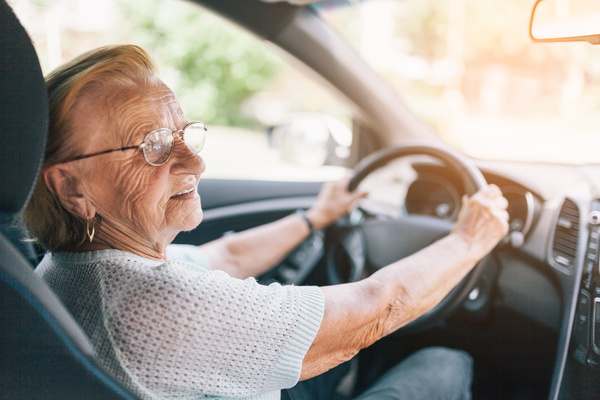 Elderly woman behind the steering wheel | Pension de reversion modèle de voiture retraite