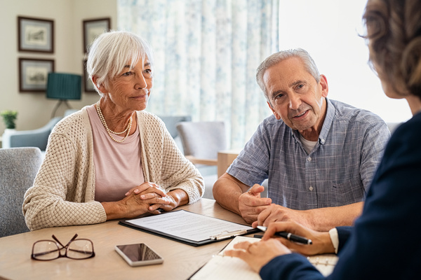 Senior couple planning their investments with financial advisor | Pension de reversion Un couple anticipant les coûts d'un conseil en retraite.