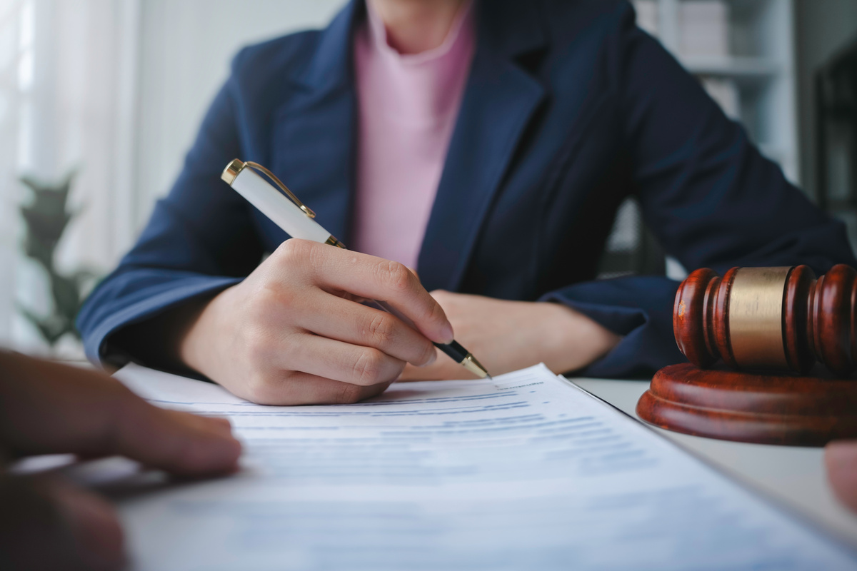 Lawyer is signing a last will and testament during a meeting with a client in their office | Pension de reversion frais de succession