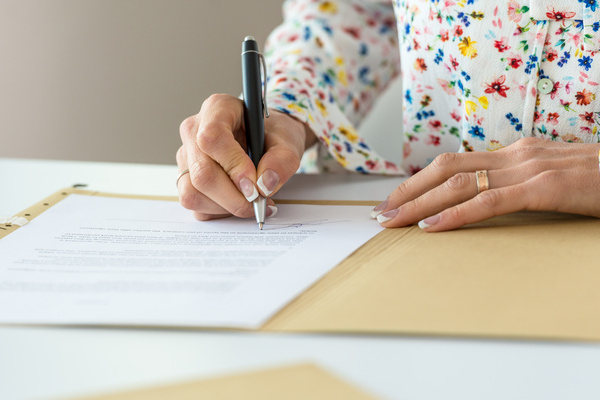 Businesswoman signing contract | Pension de reversion rédiger son testament sans notaire