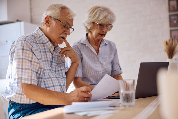 Pensive senior man analysing financial bills with his wife at home | Pension de reversion CARSAT avis d'imposition