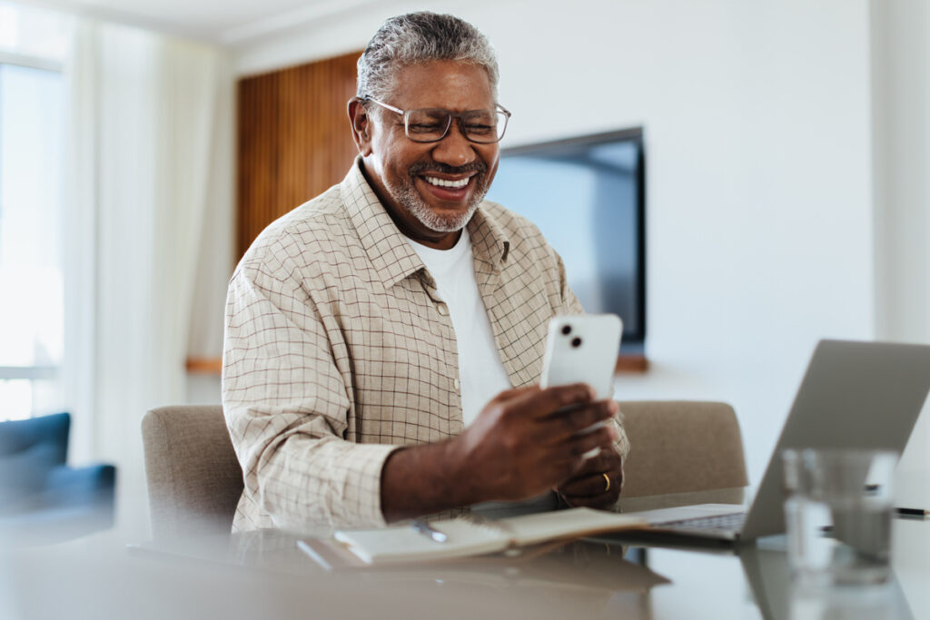 Happy mature male using phone for connecting and staying in touch | Pension de reversion date paiement CARSAT