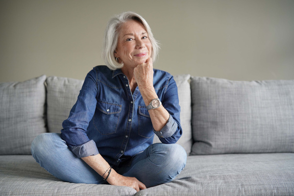 Modern senior woman in all denim on couch | Pension de reversion Calendrier paiement CARSAT