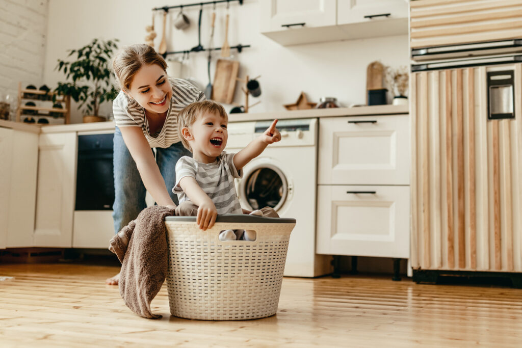 Happy family mother housewife and child in laundry with washing machine | Pension de reversion femme au foyer retraite