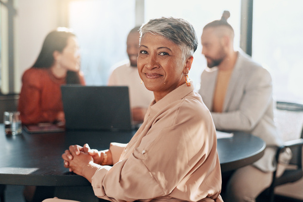 Happy woman portrait and business meeting with team management and staff in office for workshop partnership and startup success Smile motivation and mature manager in collaboration with workers | Pension de reversion valider un trimestre retraite