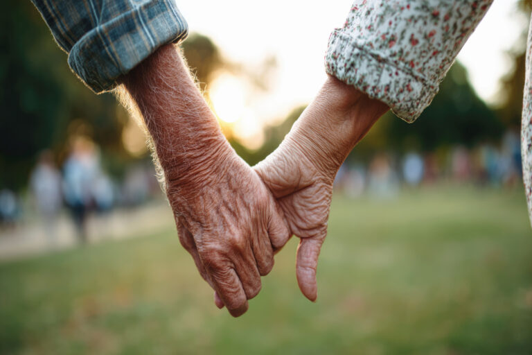 Couple de seniors se tenant la main pour illustrer comment optimiser sa réversion avec la surcote en 2026.
