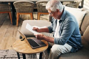 Ressources pension de réversion : déclaration Carsat | Pension de reversion Un senior examine ses documents administratifs pour déclarer ses ressources pour la pension de réversion à la Carsat.