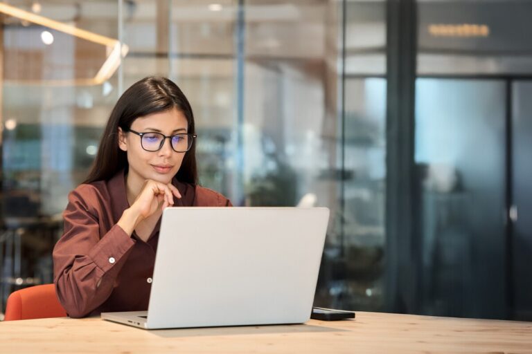 Femme concentrée sur son ordinateur effectuant ses démarches pour une pension de réversion après un décès.