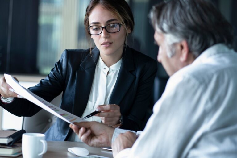 Avocate conseillant un client sur un dossier de succession et dettes professionnelles.